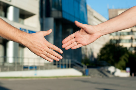 men shaking hands on building background