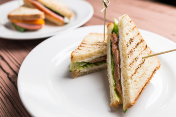 Club sandwich with salmon on white plate