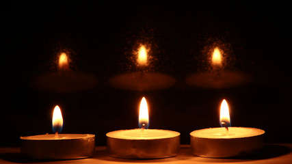 Burning candles on dark background