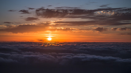 Fototapeta na wymiar Sunrise over sea of clouds