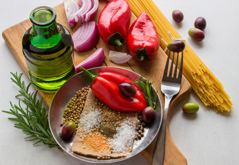 Raw pasta and spices on a light table.