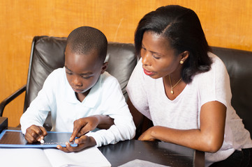schoolboy studying with his mother.