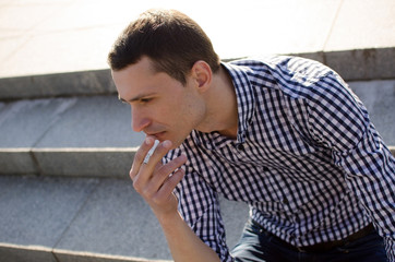 Obraz premium Young man smoking cigarette 