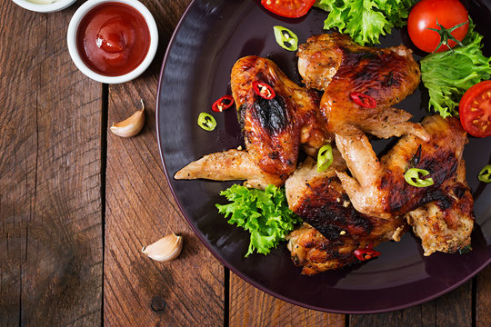 Baked chicken wings in the Asian style on plate. Top view