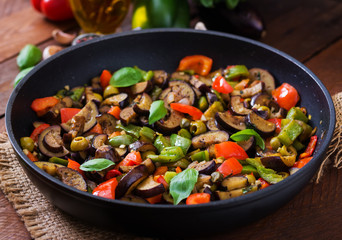 Hot spicy stew eggplant, sweet pepper, olives and capers with basil leaves.