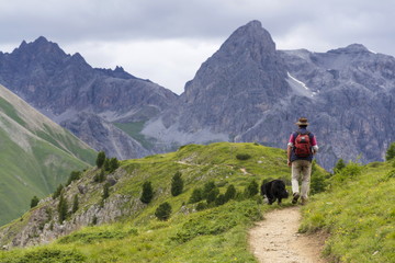 Fototapeta na wymiar Herdsman with sheepdog in Alps mountains, Livigno, Italy