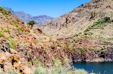 Red mountains, dark water and blue sky
