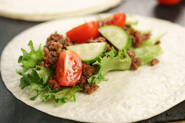open tortilla with beef, frillice and vegetables