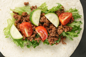 open tortilla with beef, frillice and vegetables