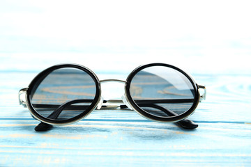 Fototapeta na wymiar Black sunglasses on a blue wooden table