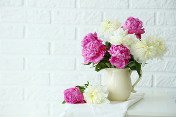 Bouquet of pink and white peony flowers on brick wall background