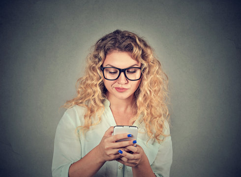 upset woman texting on mobile phone displeased with conversation