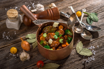 Meat stew with vegetable on rustic wooden background