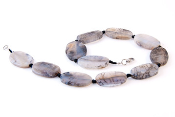 Agate necklace on white. Shallow depth of field. Focus on the closest beads.
