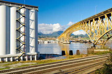 Industrial Building over empty railways and nice yellow bridge across the inlet in Vancouver, Canada.