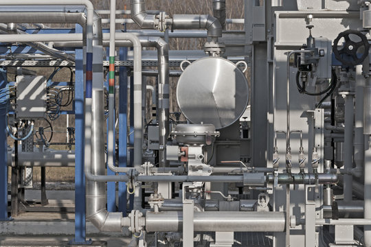Details of a modern natural gas processing plant with pressure dials on gasworks pipes