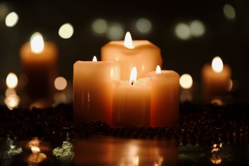 Christmas decoration with four candles in foreground and defocused candles in background