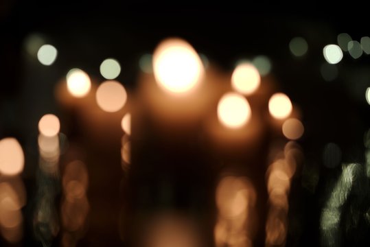 Defocused burning candles in darkness