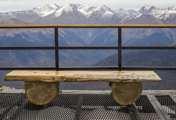 Empty wooden bench for rest with view at snow mountains