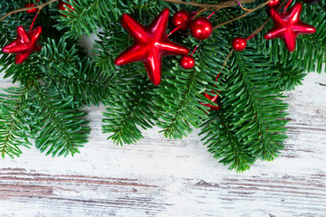 Fototapeta na wymiar christmas fresh evergreen tree branches with red garland on wood