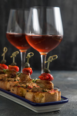 spanish tapa pinxtos with tuna, peper, onion and oregano. Wine on background