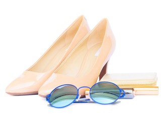 Nude colored high heels still life with wallet, sun glasses isolated on white background