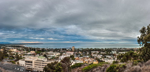 Naklejka premium Ominous rain clouds moving over panoramic city of Ventura at dawn.