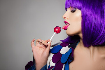 beautiful girl with purple hair. girl holding a lollipop