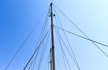 The mast of the ship on a background of blue sky