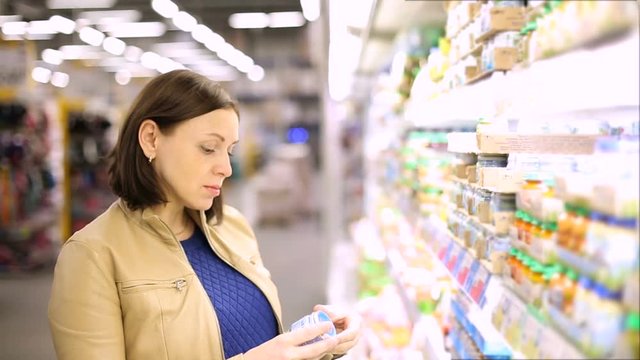 woman chooses baby food in the supermarket
