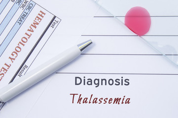 Diagnosis Thalassemia. Written by doctor hematological diagnosis Thalassemia in medical report, which are result of blood test and glass slide with blood smear 