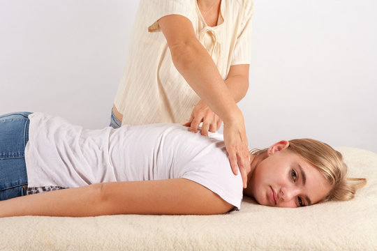 Young woman receives bowen therapy for her back and neck