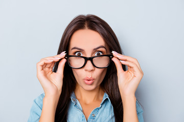 Wow! Shocked pretty woman touching her glasses