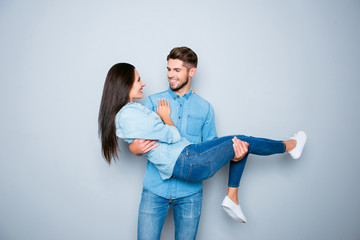 Happy smiling young man carrying his pretty girlfriend