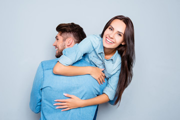 Fototapeta premium Happy man carrying his joyful girlfriend on the back