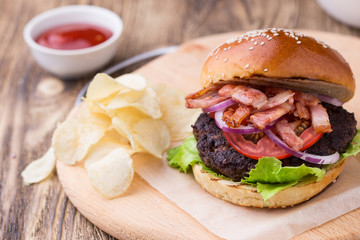 Burgrer with bacon on wooden board