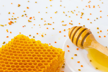 Honeycombs and honey dipper.Pollen  on a white background