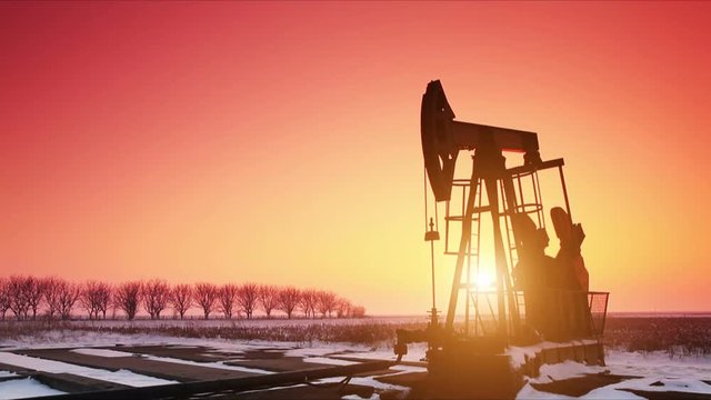 Oil field pumpjack silhouette with setting sun. Lens Flare.