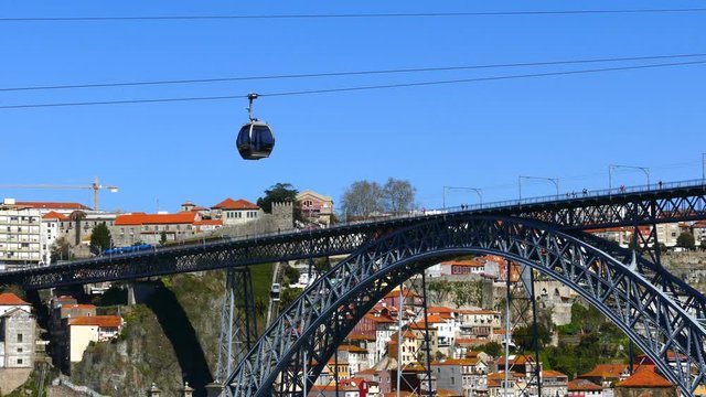 PORTO PORTUGAL, MARCH 2015. Old colorful houses in old part of Porto and cable car over Douro river. Dom Luise 1 bridge in the background .4K