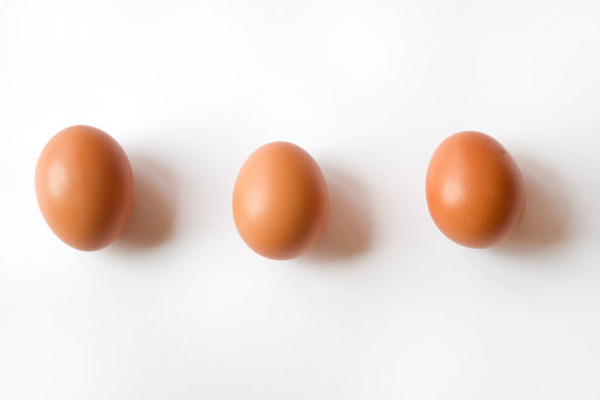 Three Fresh Organic Brown Eggs isolated on a White Background
