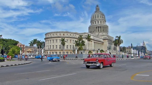 HAVANA, CUBA - OCTOBER 8, 2014: Old classic American cars on the streets of Havana city, Cuba.Capital building.Urban scene, people and traffic
