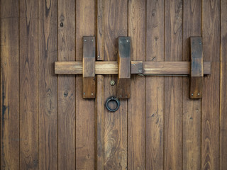 Old wooden gate closed with a big bolt