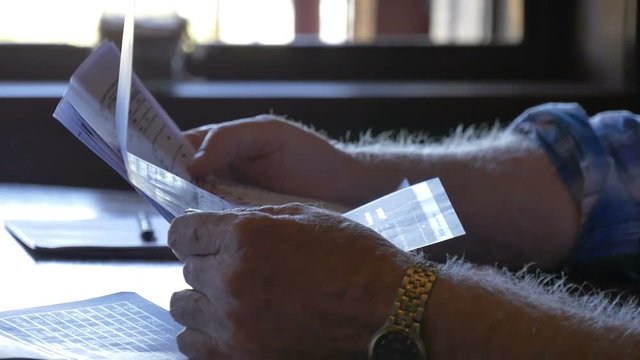 Pensioner old man looking at overdue bills retirement money trouble