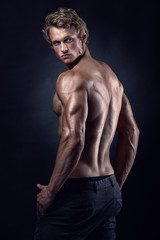 Obraz na płótnie Canvas Strong Athletic Man Fitness Model posing back muscles