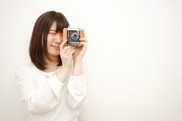 Young woman holding a camera with smile