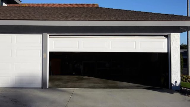 A residential home with an automatic roll up garage door moving in the closing position..