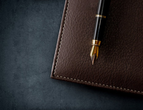 Leather brown notebook with fountain pen.