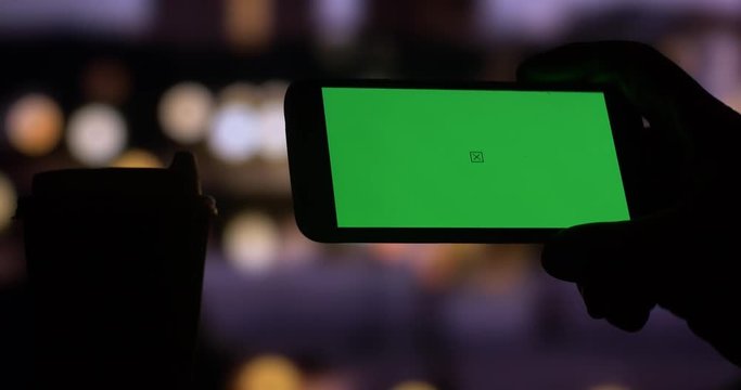 Using smart phone with Green Screen city night bokeh background