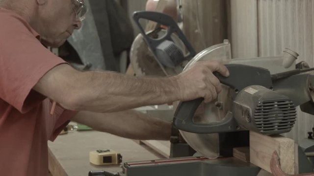 Man working indoors in hobby shed or workshop with carpentry power tools