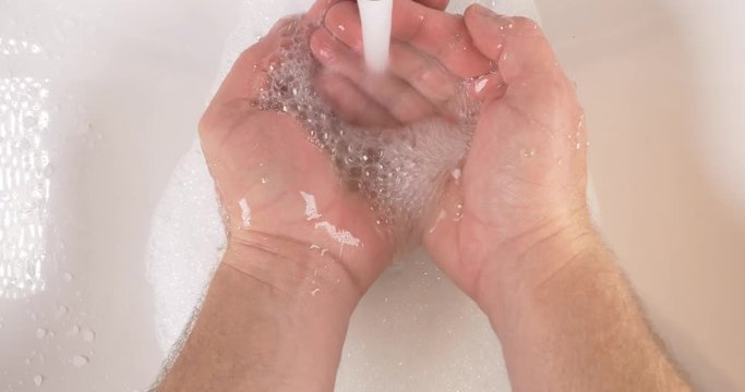 Washing hands in sink with soap to clean skin for good hygiene